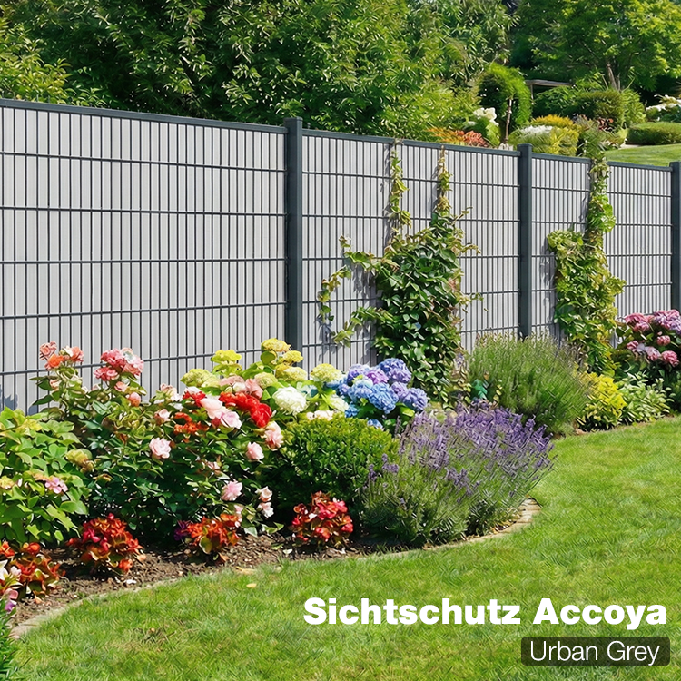 Sichtschutzzaun Accoya Urban Grey als Gartenzaun mit blühendem Beet im Hintergrund