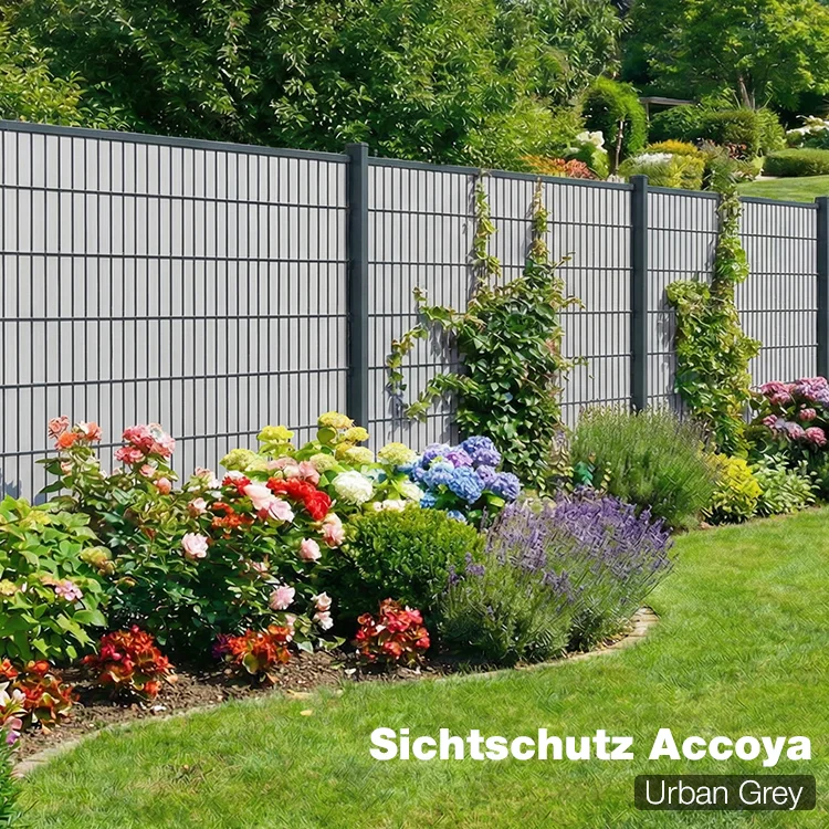 Sichtschutzzaun Accoya Urban Grey als Gartenzaun mit blühendem Beet im Hintergrund