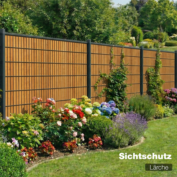 Sichtschutzzaun Lärche als Gartenzaun mit blühendem Beet im Hintergrund